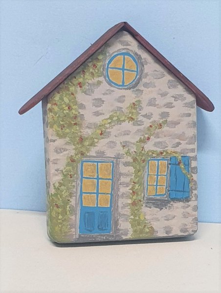 Haus mit Holzdach (mit Pflanzenranken)